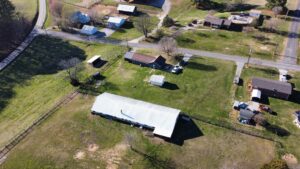 Aerial view of farm property on Riddle Road, featuring main house, barn, fenced pasture, and outbuildings