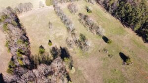 Aerial view of farm property on Riddle Road, featuring main house, barn, fenced pasture, and outbuildings